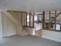 Living room through to kitchen with bespoke ash staircase and exposed original timberwork